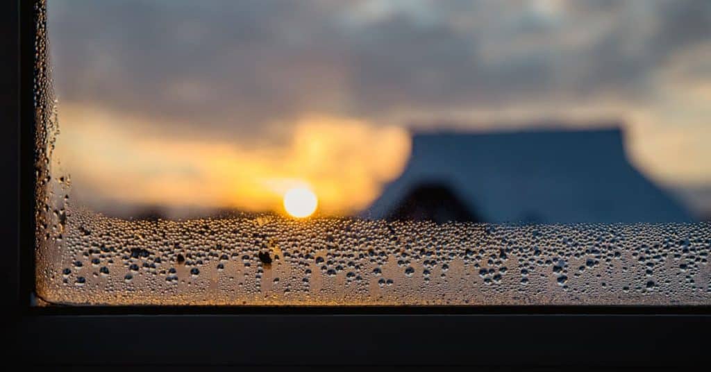 Condensation sur fenêtre avec soleil en arrière-plan