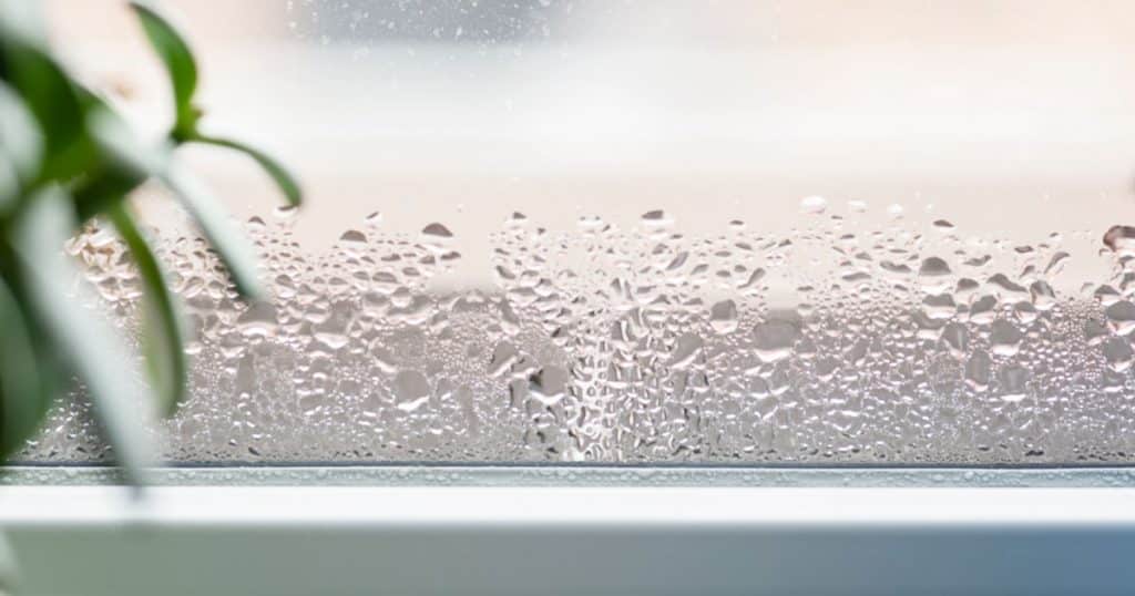 Zoom sur le bord d'une fenêtre qui présente de la condensation. 