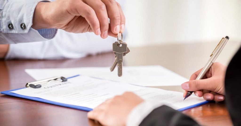 Signature d'un contrat de vente immobilier et remise de clé au nouveau propriétaire