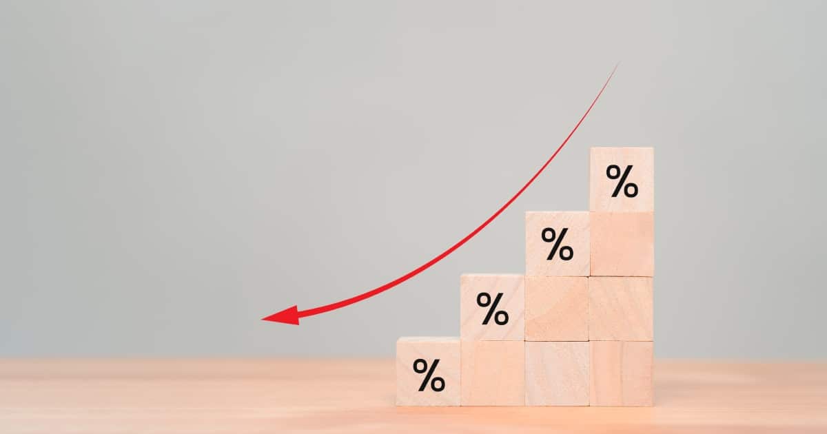 Blocs de cube en bois avec pourcentage et icône flèche vers le bas. Le concept commercial de revenu a diminué, l'investissement réduit, la crise financière, la baisse des taux d'intérêt, la gestion des risques.
