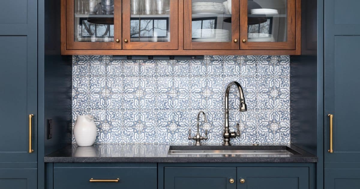 Carreaux en céramiques sur mur derrière l'évier de cuisine et façades bleu foncé