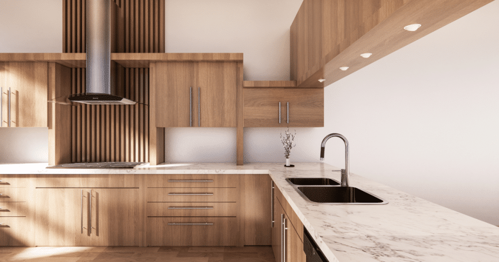 Cuisine moderne au design minimaliste avec armoires en bois clair, plan de travail en marbre blanc, hotte en inox et évier double sous un éclairage intégré.