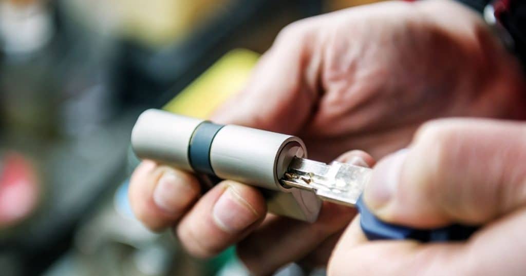 cylindre de porte dans les mains d'un serrurier avec une clé