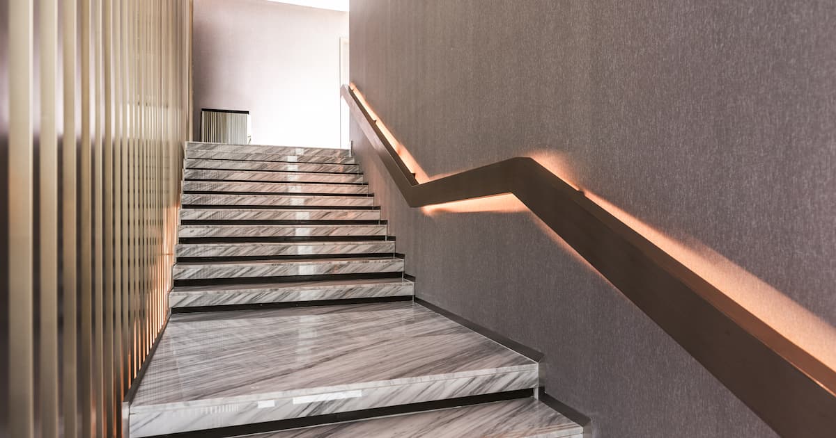 Escalier en marbre blanc avec rampe éclairée