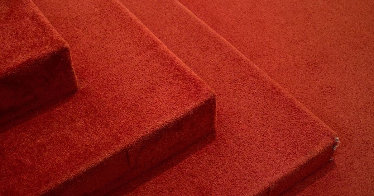Marche d'escalier recouverte d'une moquette rouge