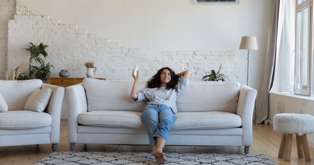 Une dame qui, grâce à la location d'une climatisation multi-split, peut réguler la température de son bureau à domicile d'un simple clic de bouton.