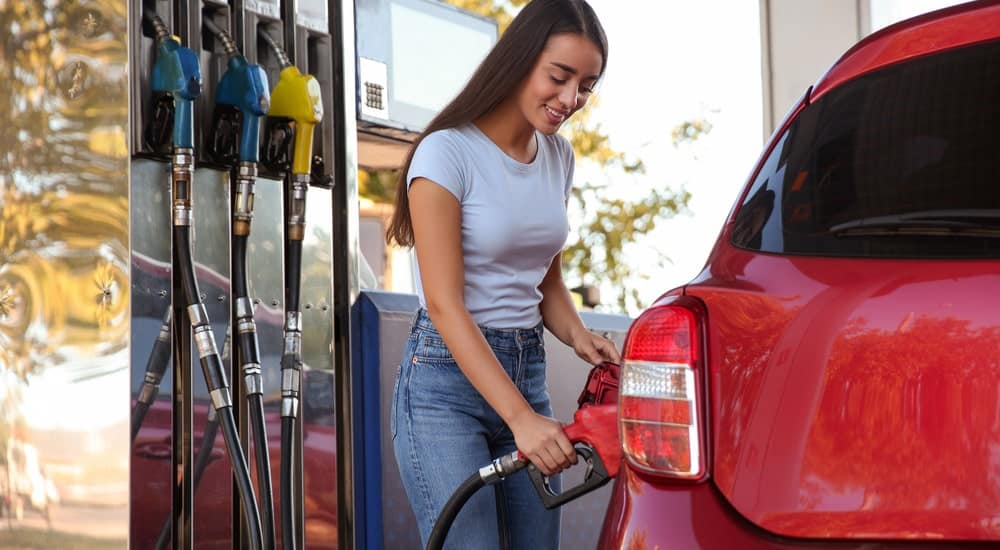 Une femme met de l'essence dans sa voiture avec sa carte Fleetpass
