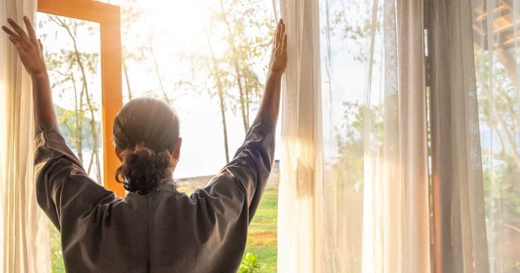 Femme qui ouvre une fenêtre pour aérer