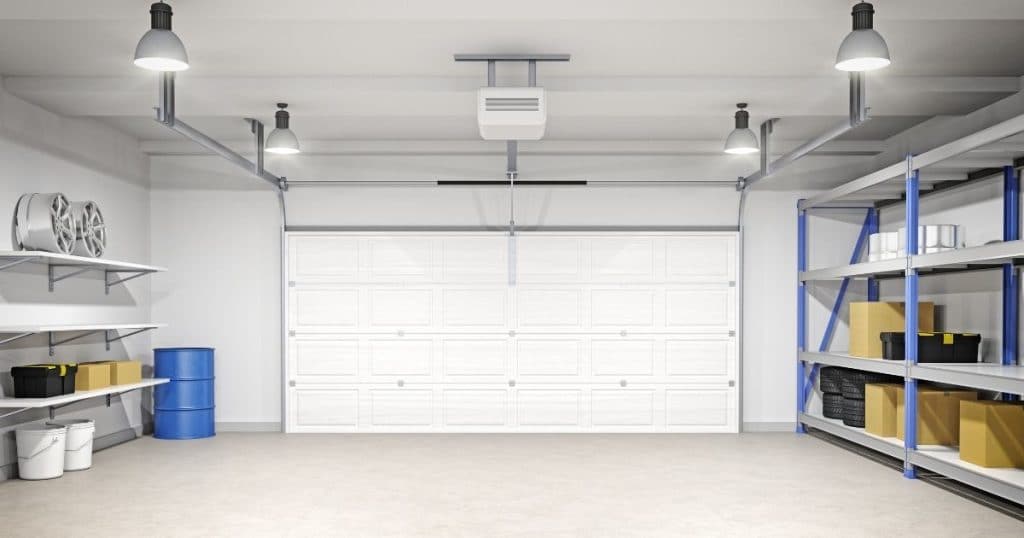 Garage isolé et emménagé avec grande porte et étagères. 