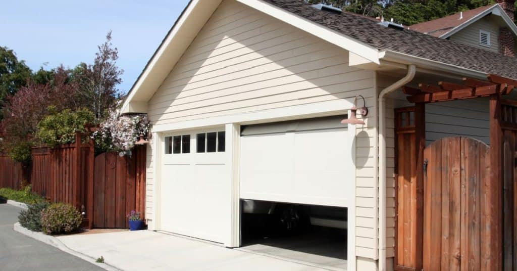 2 garages avec portes blanches devant une habitation