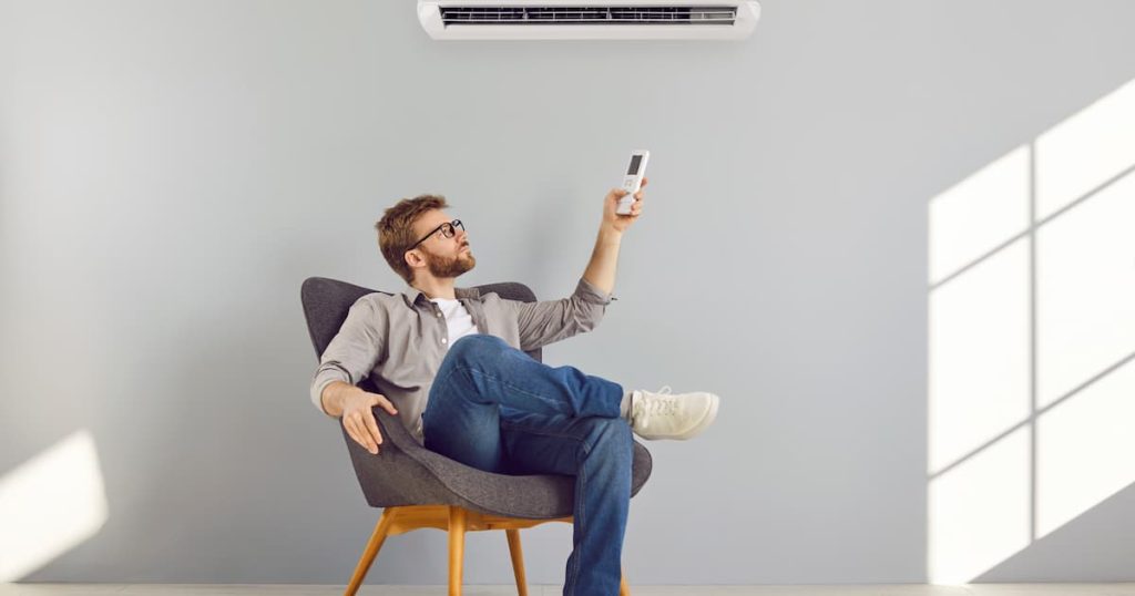 un homme en train de régler la clim