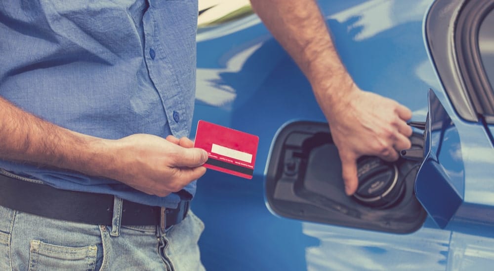 Un homme qui utilise sa carte carburant Dats 24 pour faire le plein d'essencve à la station-service