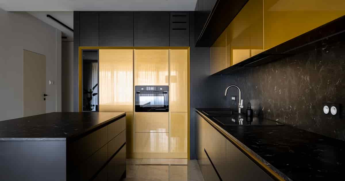 Cuisine moderne et spacieuse avec mobilier noir et doré, carrelage en marbre et plans de travail noirs, arrière-plan et cuisine élégante île