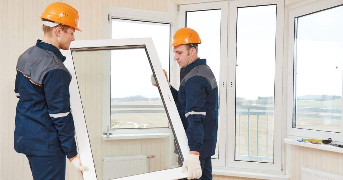 2 hommes en train d'installer une nouvelle fenêtre.