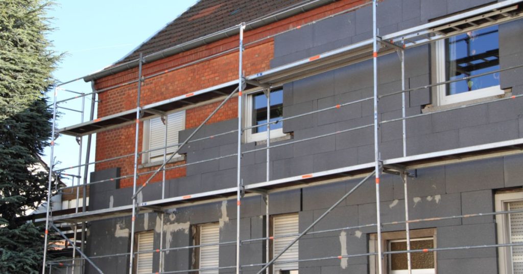 mur exterieur d'une maison en train d'être isolé par l'extérieur à l'aide de panneaux isolants. 