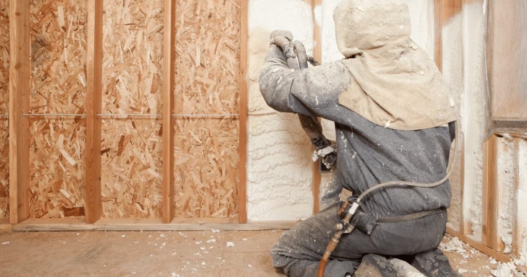 ouvrier isolant des murs intérieurs avec de la mousse isolante