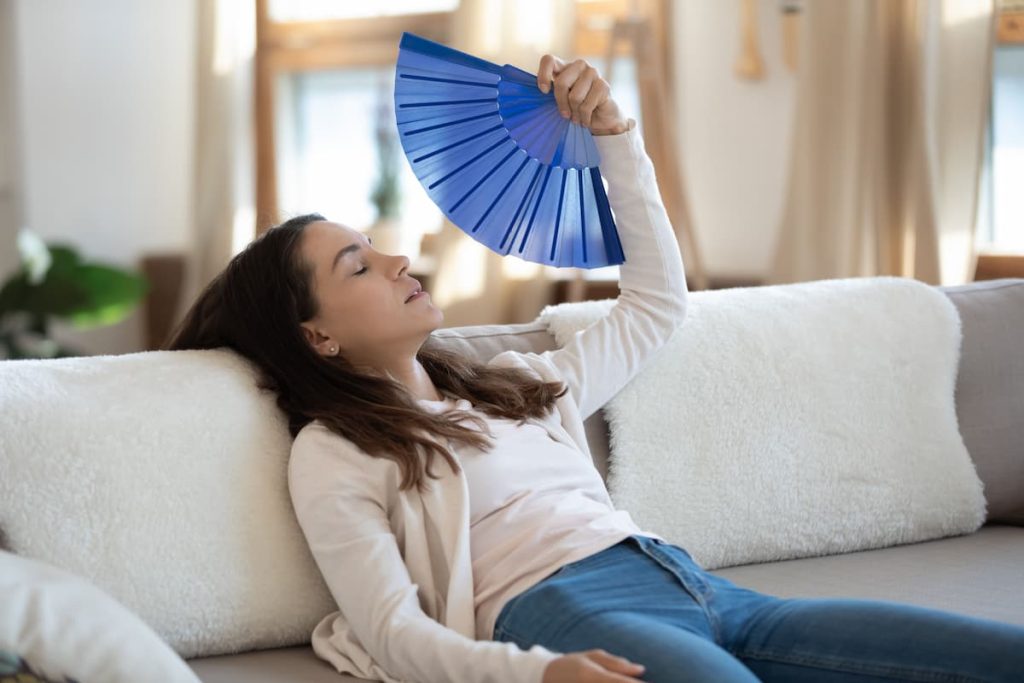 Femme dans un divan avec éventails bleu