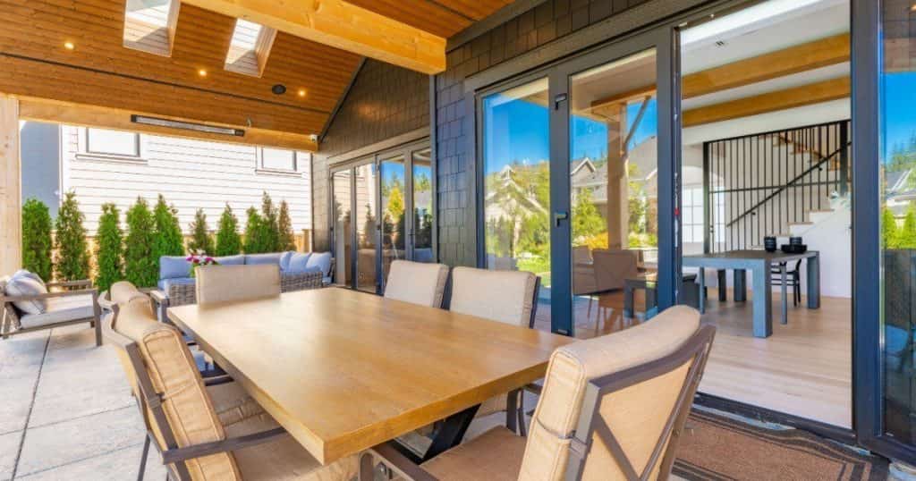 Terrasse aménagée avec table en bois et six chaises