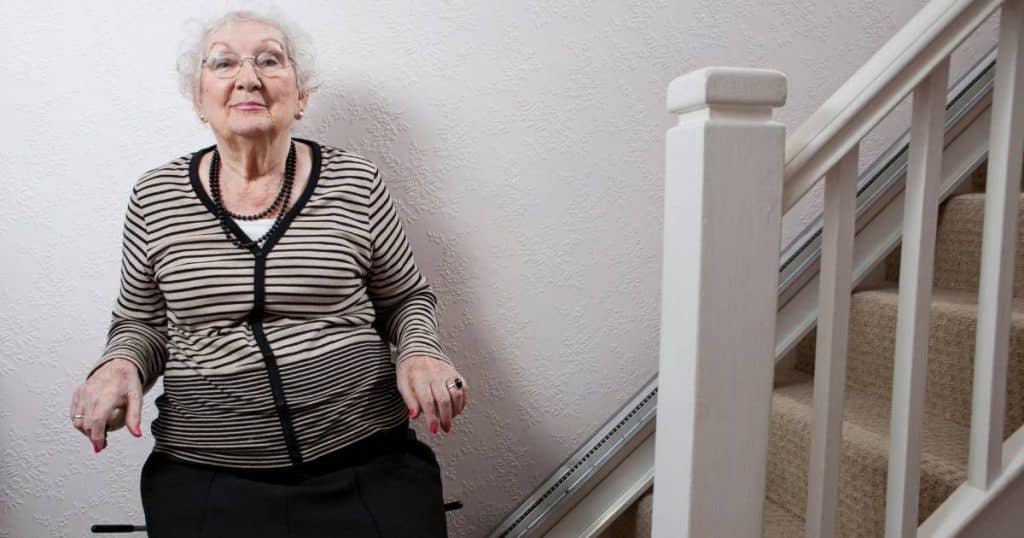 Femme âgée en train d'utiliser un monte-escalier électrique
