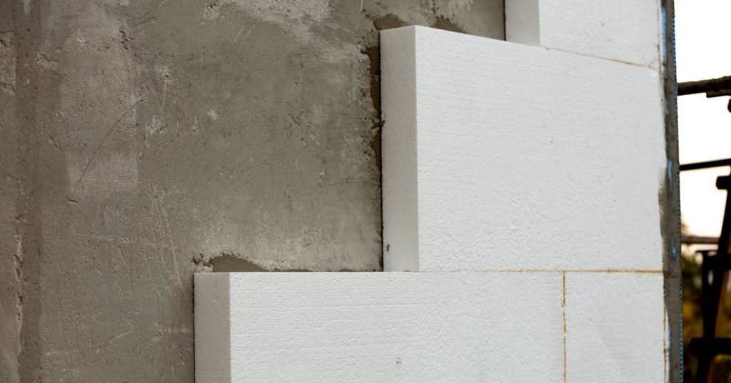 Pose de panneaux isolants sur un mur extérieur en béton