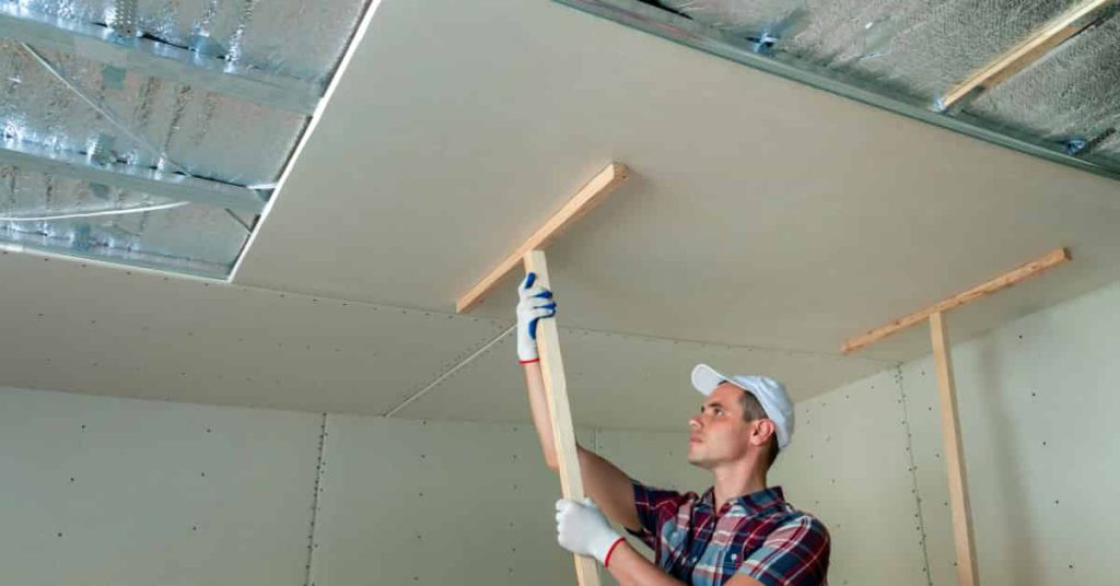 Professionnel qui pose un plafond suspendu