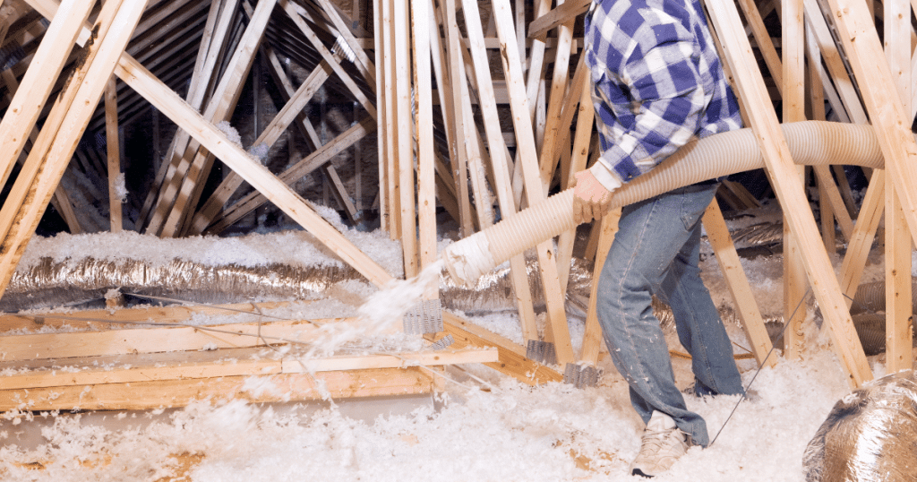 Homme qui isole le plancher d'un grenier par soufflage