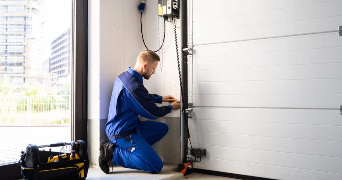 Homme en train de réaliser des travaux d'isolation sur porte de garage