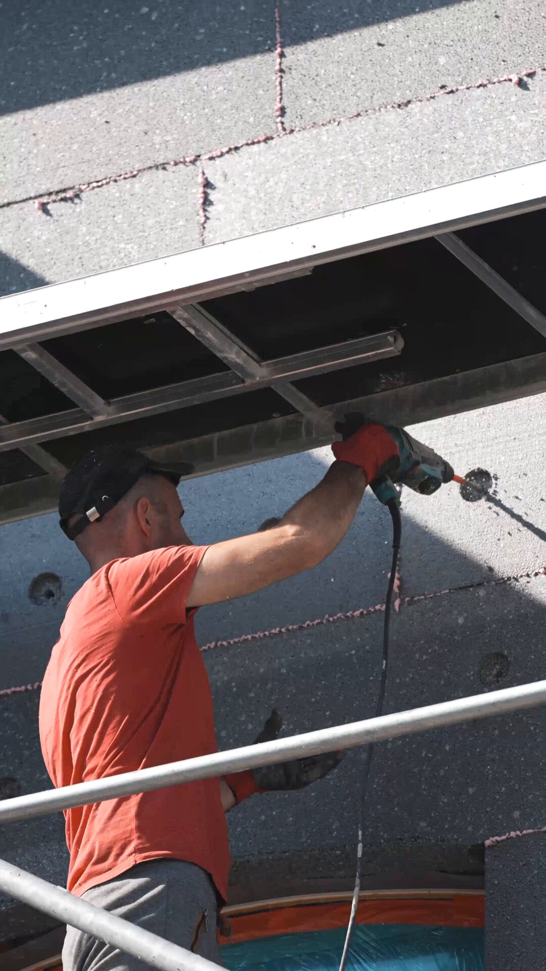 ouvrier en train de fixer une cheville pour maintenir l'isolant en EPS sur la façade