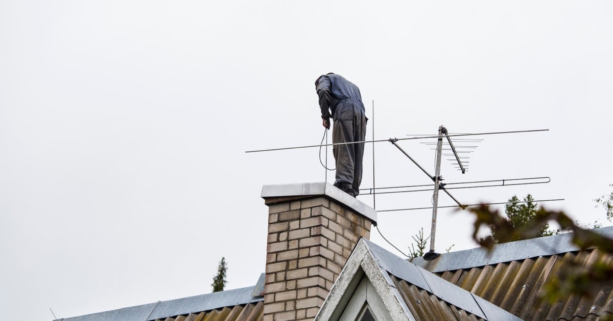 Ramoneur sur le toit d'une maison en Belgique.