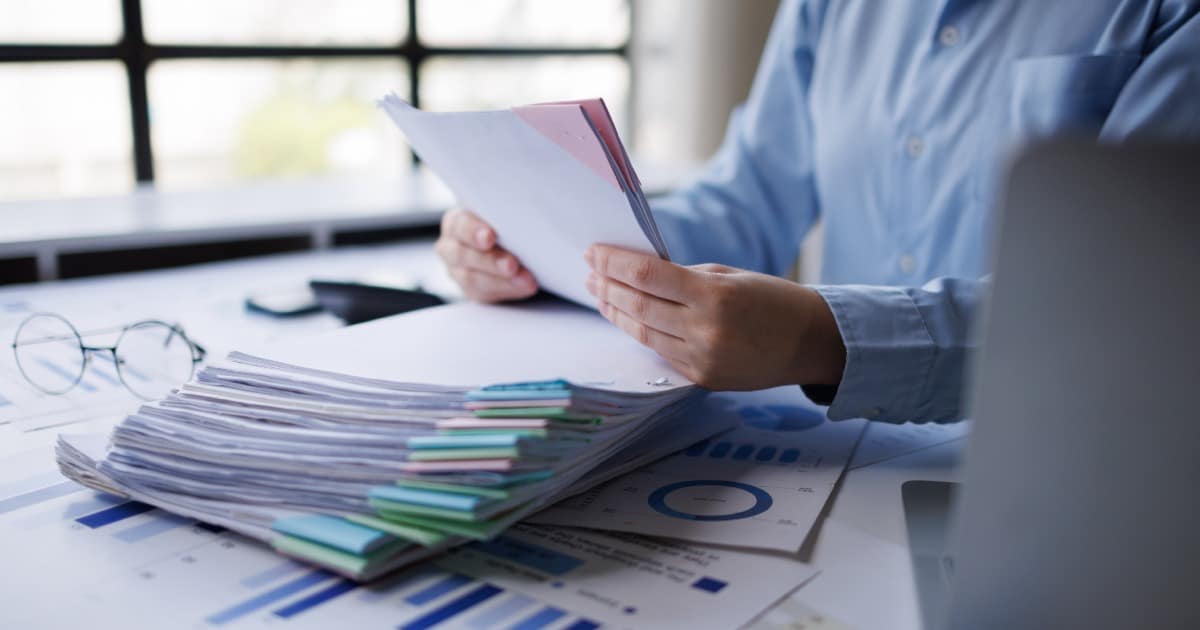 Un auditeur consultant ses rapports depuis son bureau.