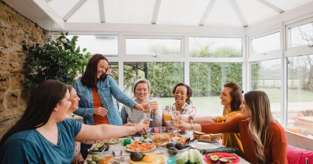 Une famille joyeuse prend un bon repas dans une véranda. 