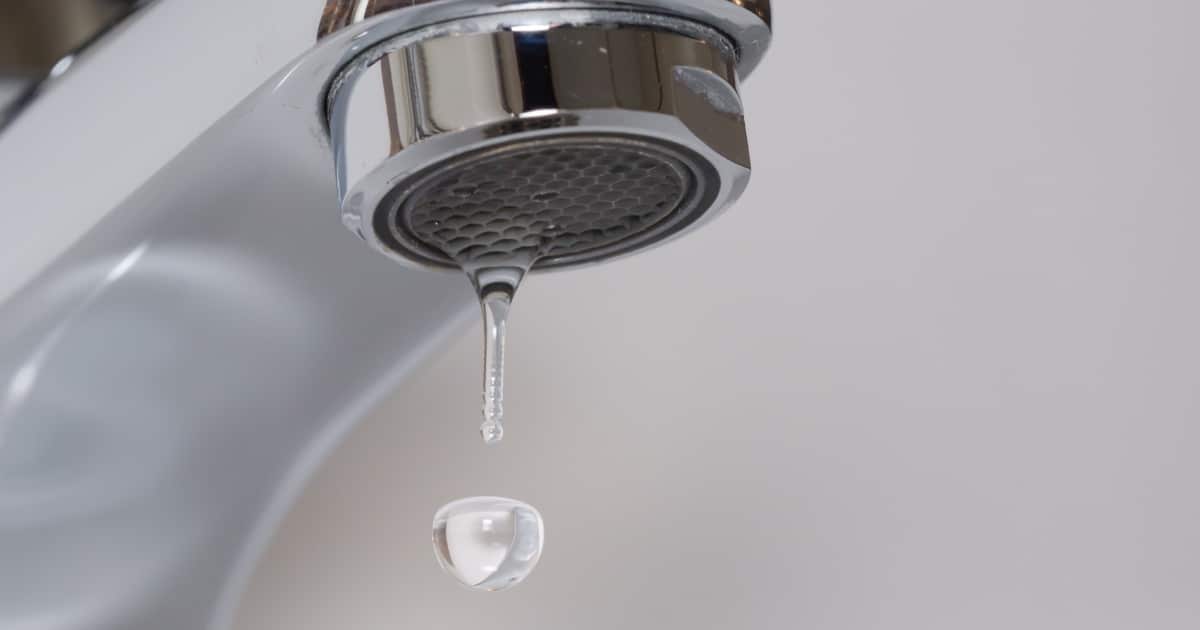 Robinet avec une goutte d'eau qui tombe vers l''évier.