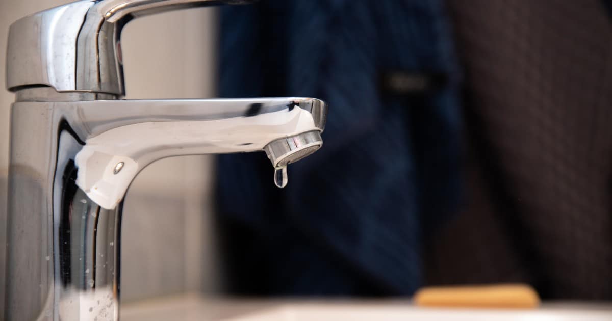 Robinet fuyant avec une seule goutte d'eau tombant.