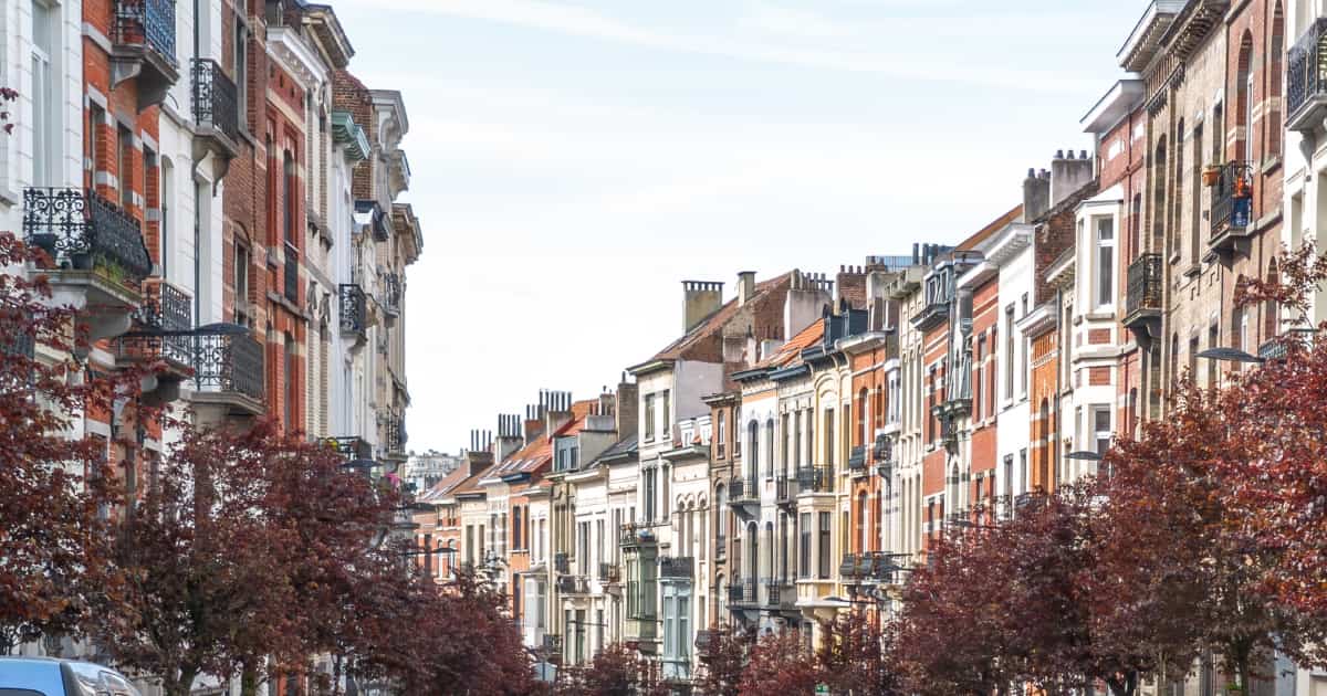 Rue d'une commune de Bruxelles où les cheminées des maisons sont apparentes.