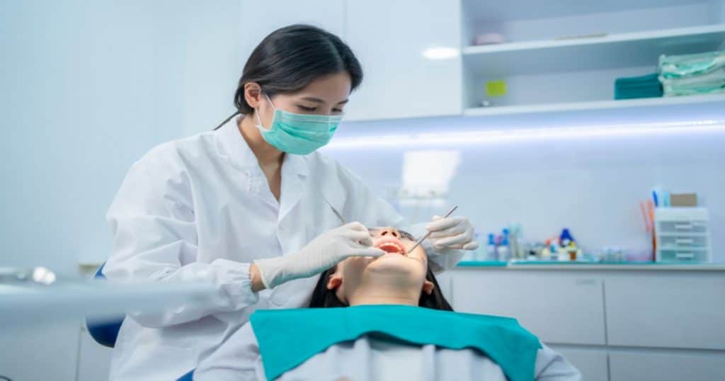 Une dentiste soigne une femme dans un cabinet dentaire. 