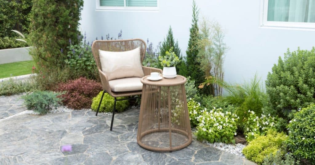Terrasse en pierre naturelle avec un fauteuil de terrasse