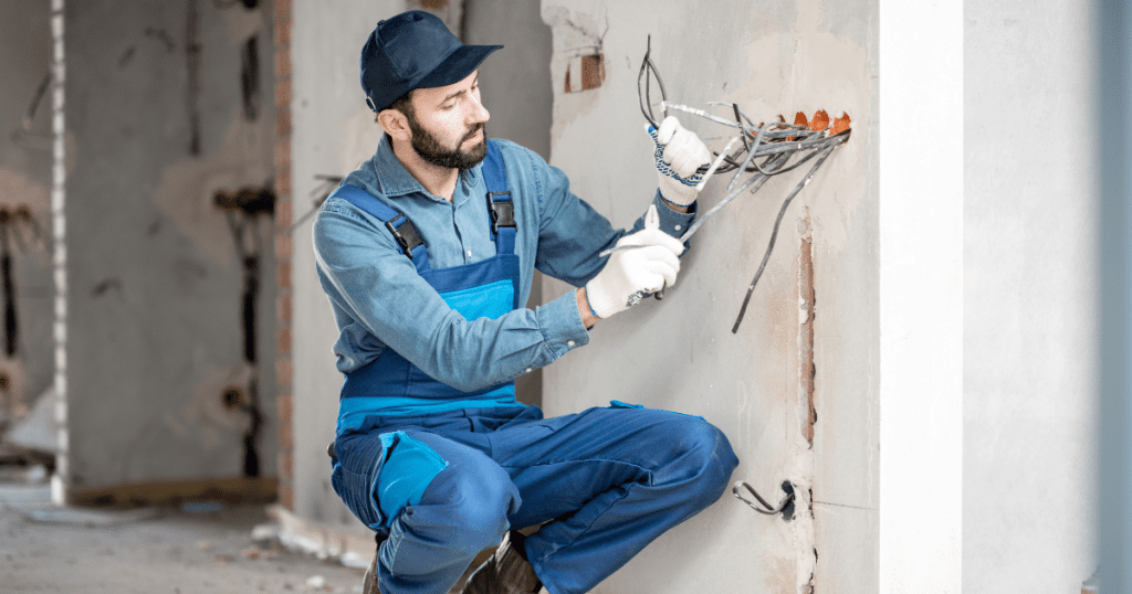 un électricien professionnel procède à un tirage de câble dans une maison 