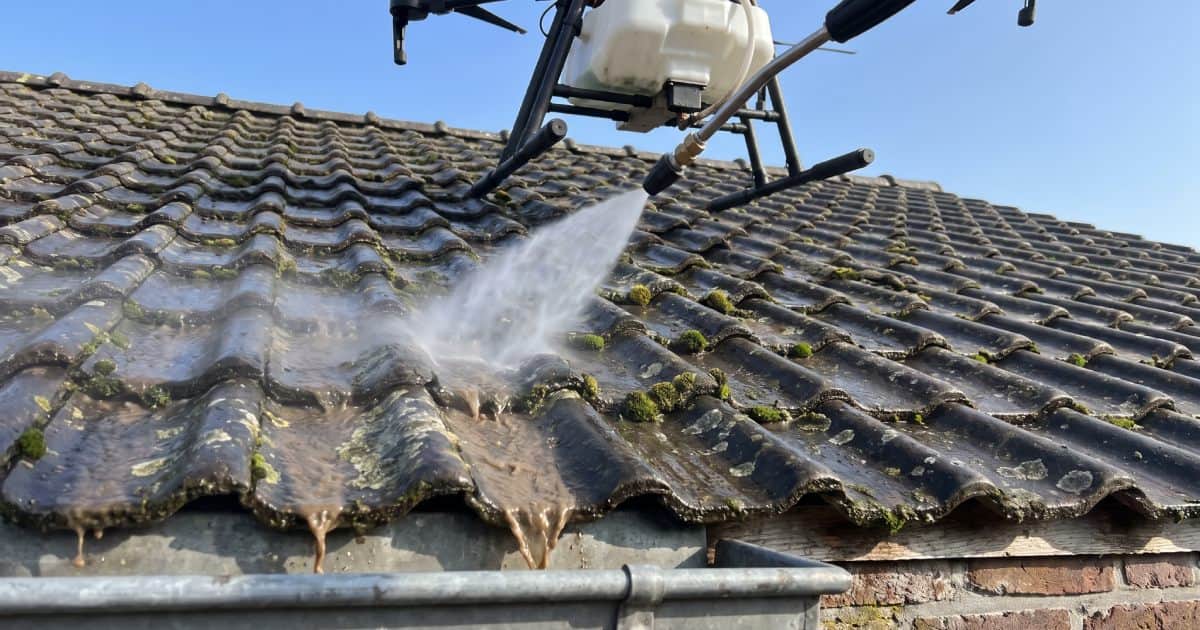 Vue de près d'un drone nettoyant une toiture plein de mousse.