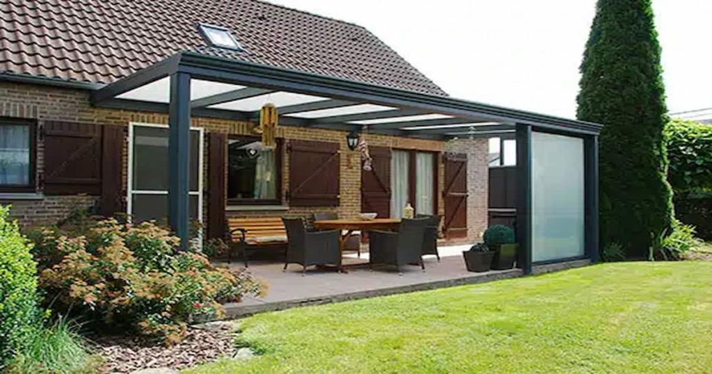 Façade et pelouse d'une maison avec un couverture de terrasse faite sur-mesure