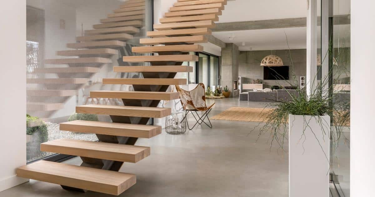 Escalier à limon central dans  une pièce de séjour à côté d'une bais vitré.