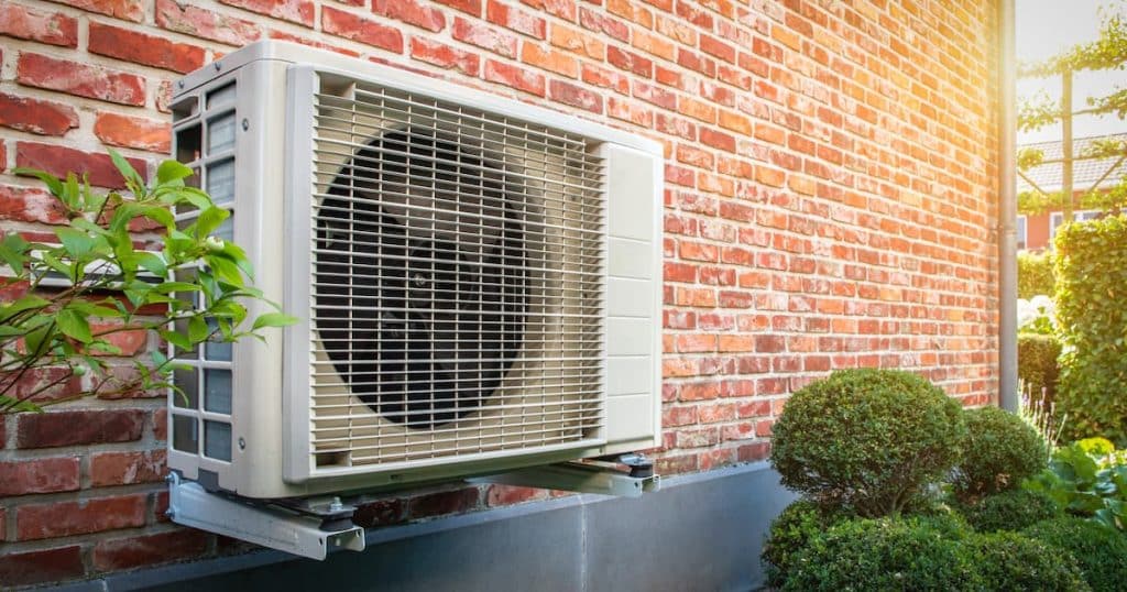 Air conditionné pompe à chaleur unité extérieure contre mur en briques.