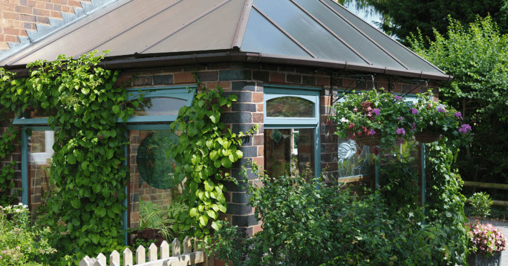 Vue d'extérieur d'une véranda en pierre avec des plantes 