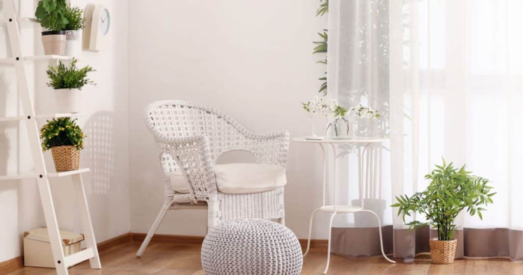 decoration d'une veranda avec l'aménagement d'un coin lecture zen composé d'un fauteuil blanc, table blanche et un support blancs avec quelques plantes d'intérieur