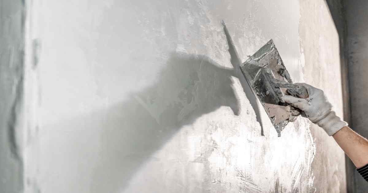 Specialist doet sierpleister op de muur