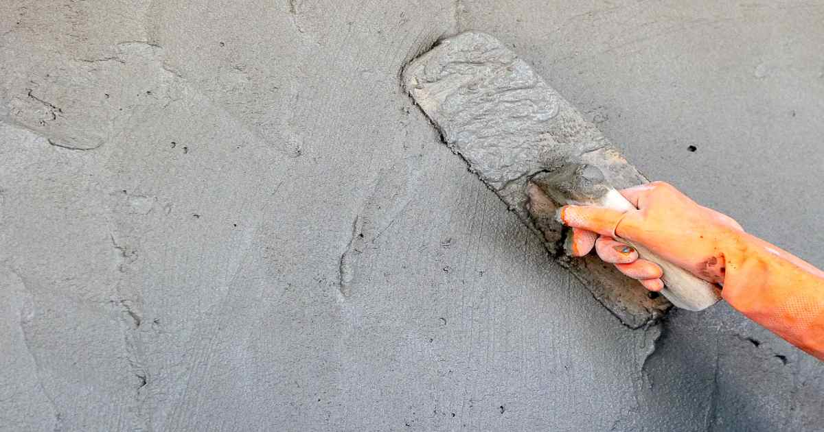 Vakman brengt cementpleister aan