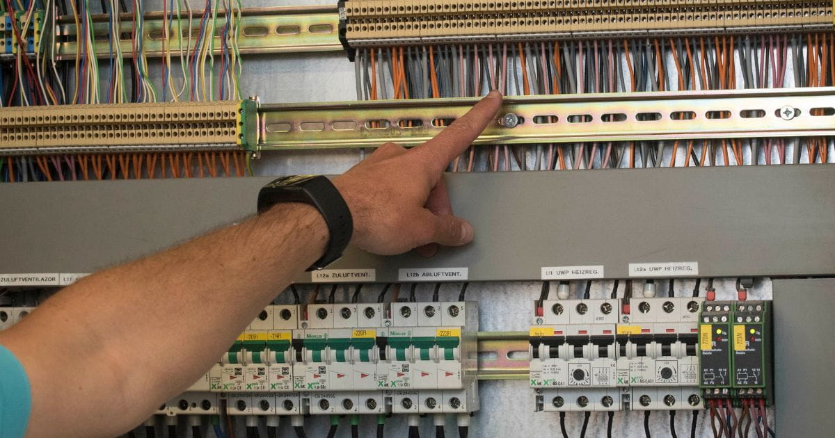 Verschillende zekeringen en automaten zijn in een elektriciteitskast verbonden door bekabeling