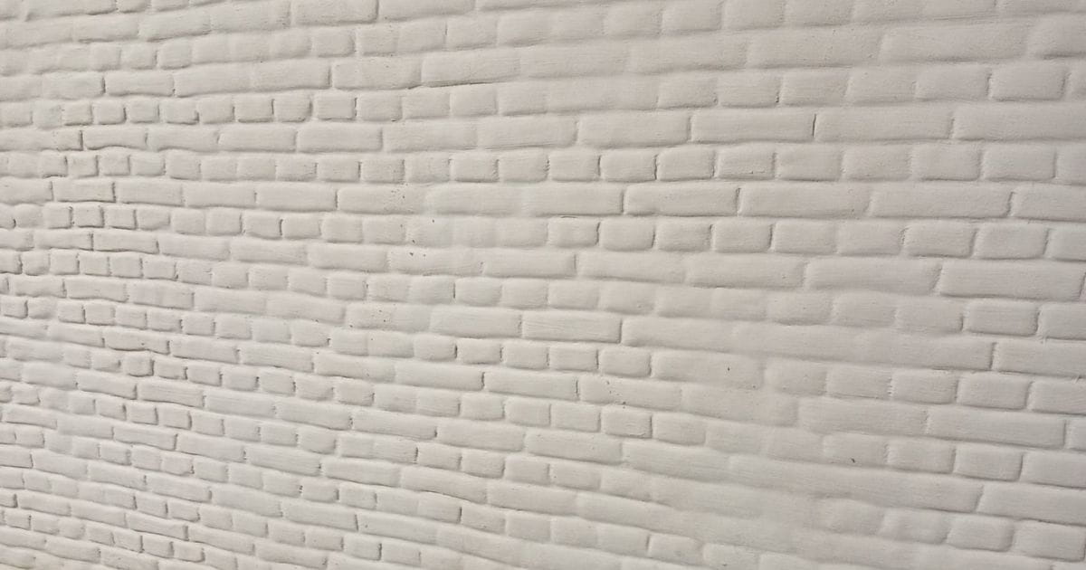 Witte crepi met baksteenmotief close-up