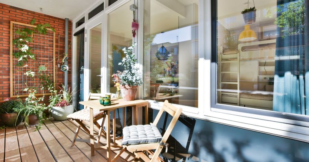 Houten veranda met glazen wanden en planten, voorbeeld om de veranda prijs en uitstraling te vergelijken.