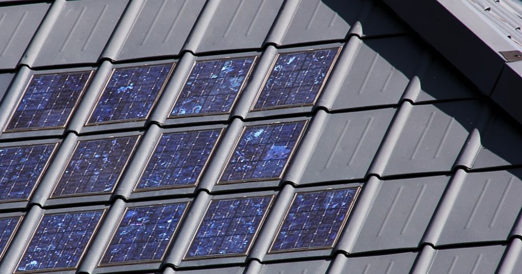 Keramische zonnepannen naast zwarte dakpannen op een hellend dak.