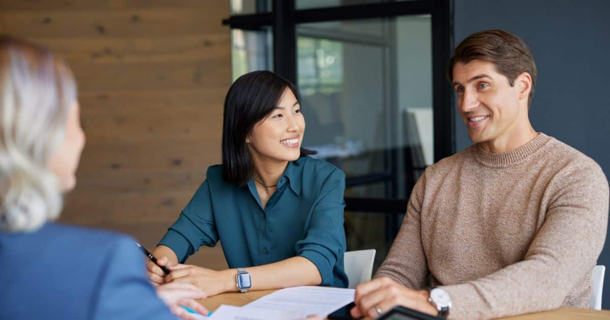 Koppel bespreekt ziekenfonds vergelijken met adviseur om terugbetalingen en voordelen te begrijpen.